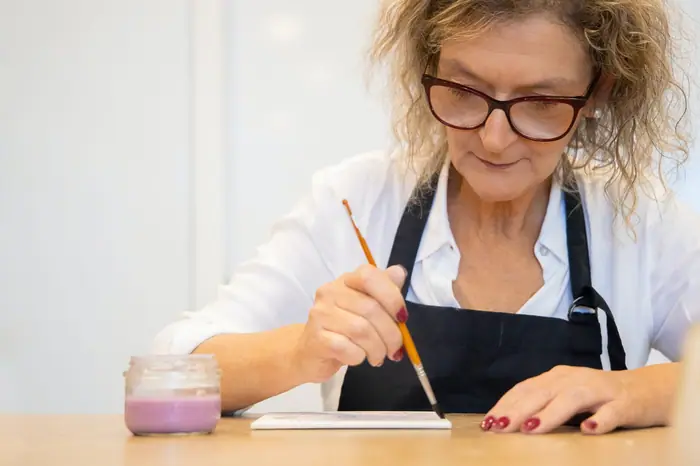 Participante concentrada pintando em ambiente interno