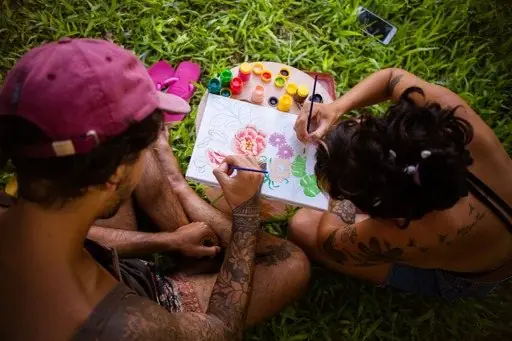 Casal pintando lado a lado, bem próximos